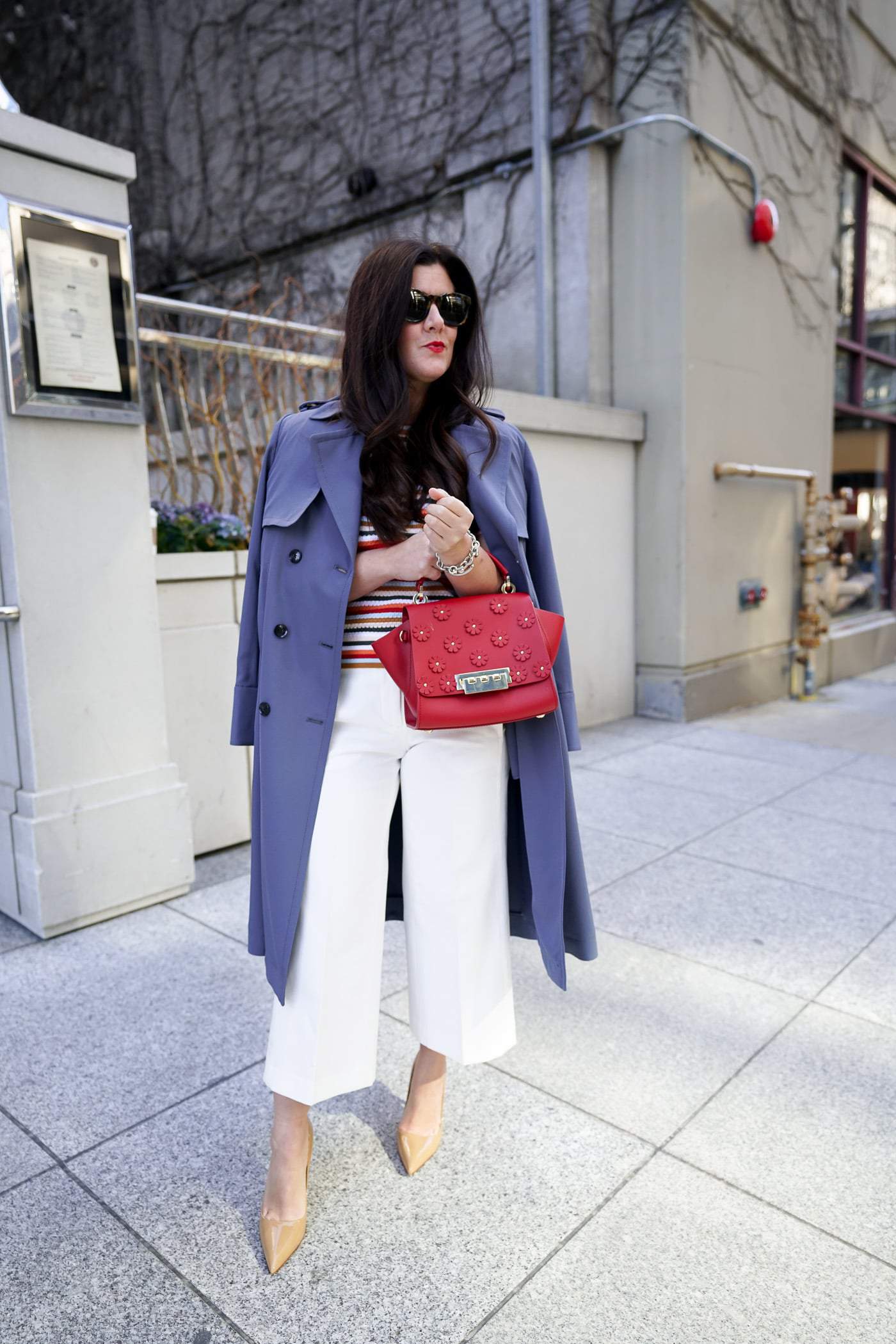 A petite women sharing how to wear a trench coat with white pants and heels