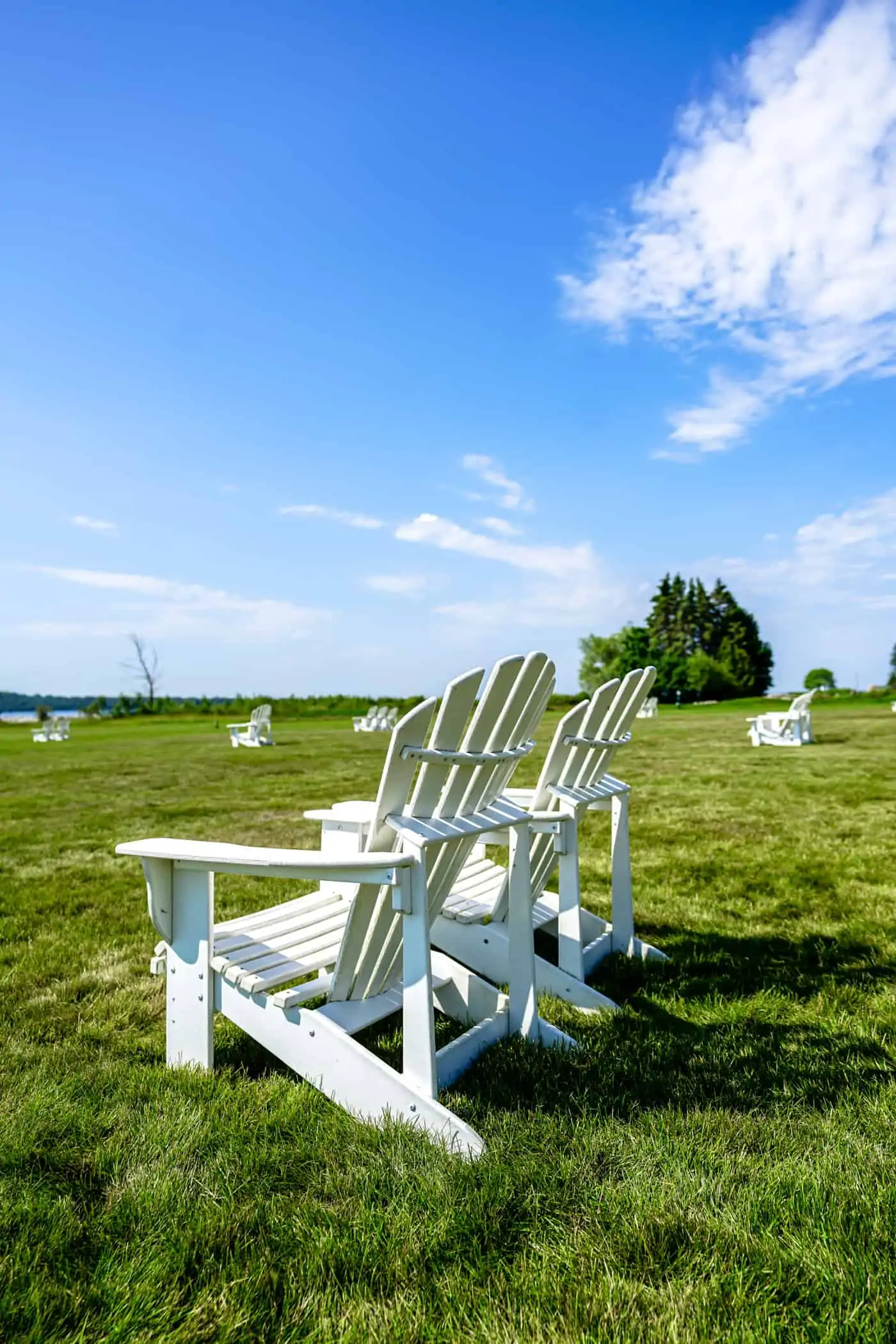 White adirondack charis on the lawn of Mission Point Resort