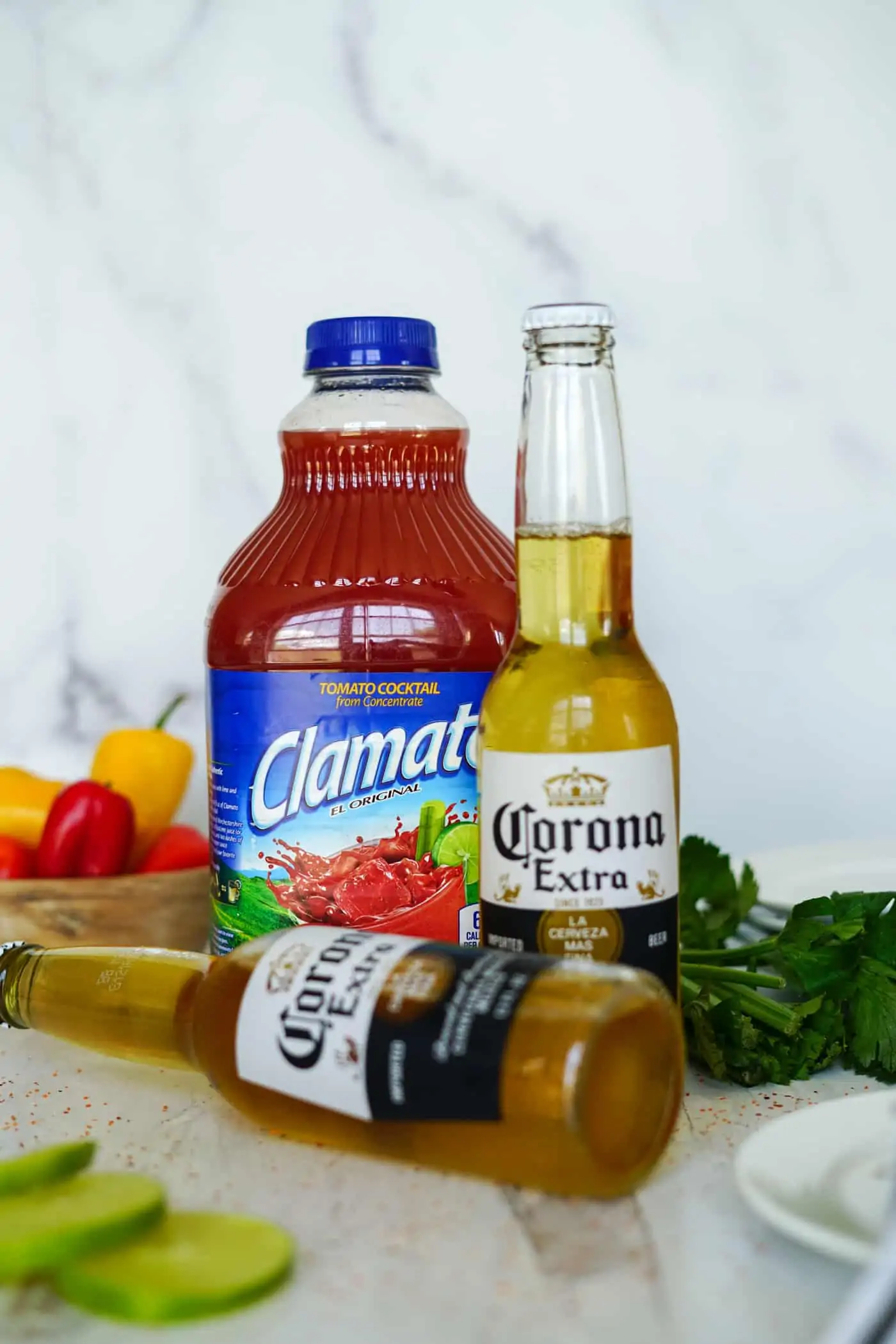 A large bottle of Clamato and two bottles of Corona beer for a Michelada recipe.